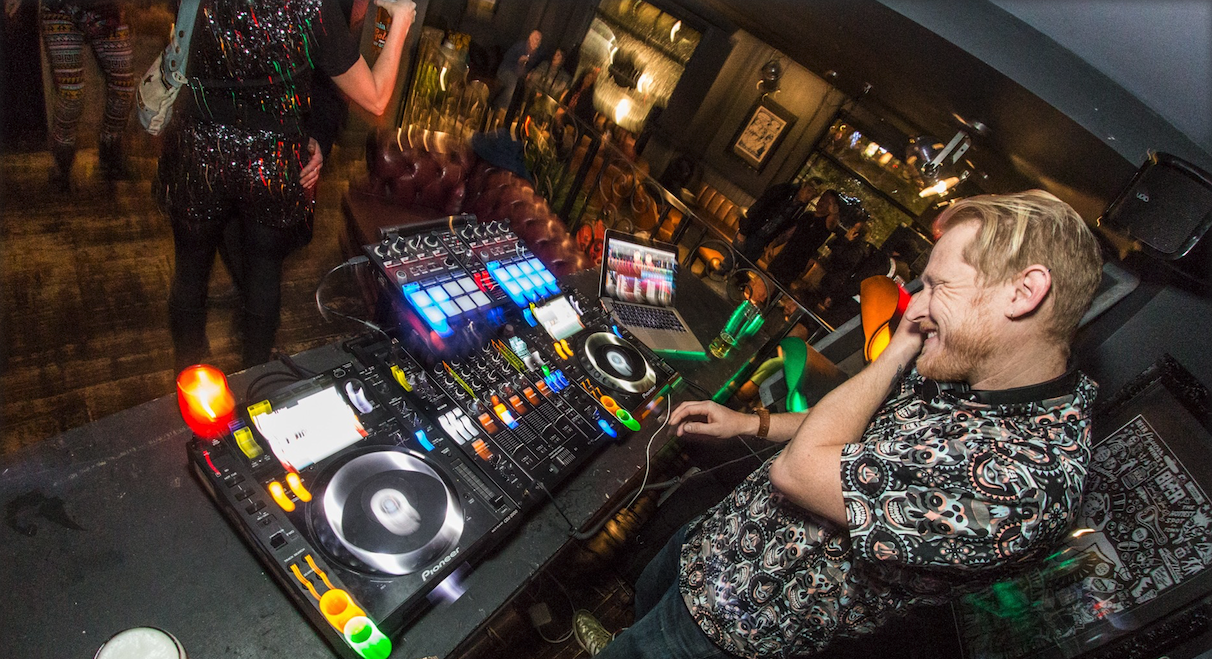 Photo of a man on a DJ mixing desk