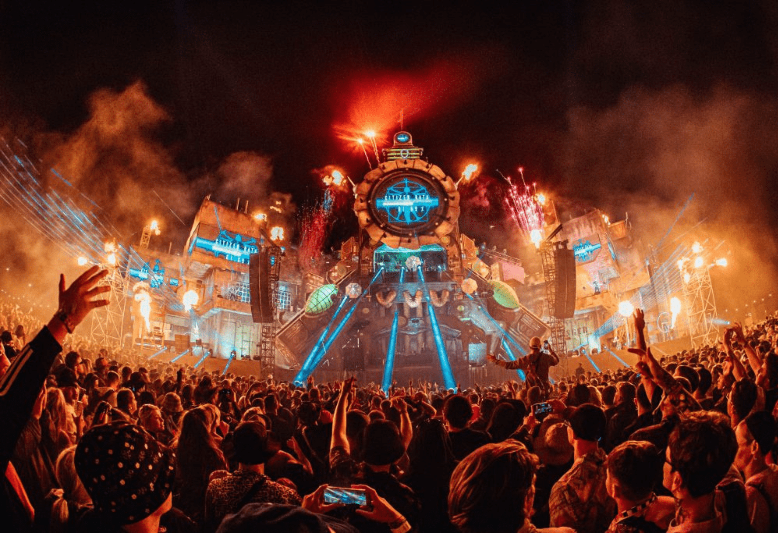 Crowd of people in front of a lit up stage at a festival to show the partnership between AF Live and Boomtown