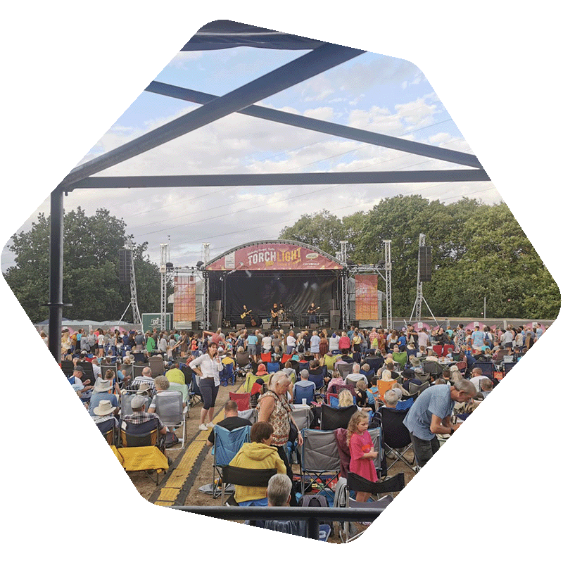 Photo from a structure of people sat in front of a stage